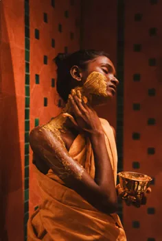 A traditional ubtan ritual — turmeric paste on skin, brass vessel in hand